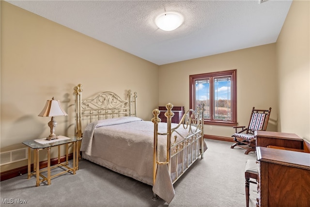 bedroom featuring carpet flooring and a textured ceiling