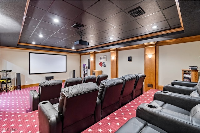 cinema room with carpet, ornamental molding, and a tray ceiling