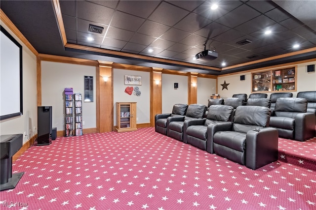 carpeted home theater room with a tray ceiling, a paneled ceiling, and ornamental molding