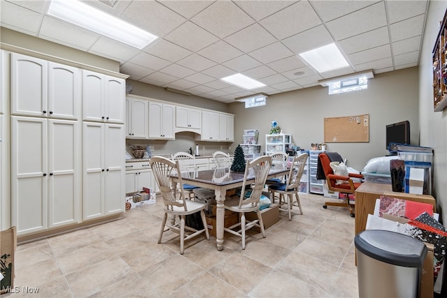 dining room with light tile patterned floors and a paneled ceiling