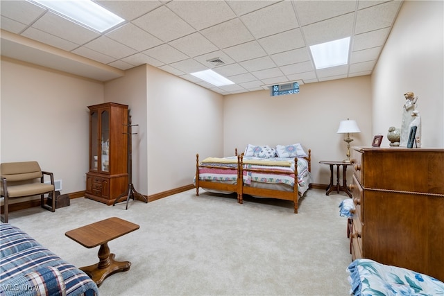 carpeted bedroom featuring a drop ceiling