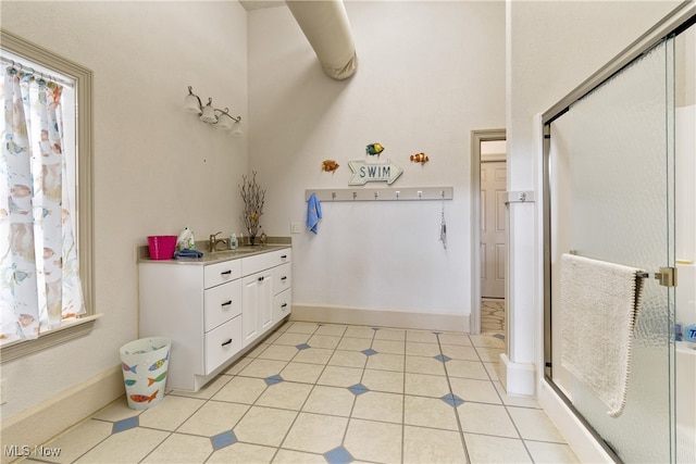 bathroom featuring tile patterned flooring, vanity, and walk in shower