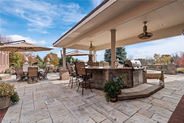 view of patio with a bar, a grill, and exterior kitchen