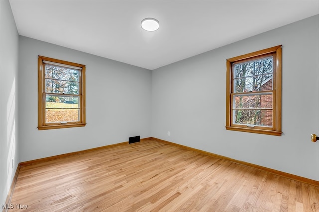 empty room with a healthy amount of sunlight and light hardwood / wood-style floors