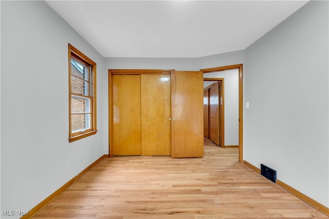 unfurnished bedroom with light hardwood / wood-style floors and a closet