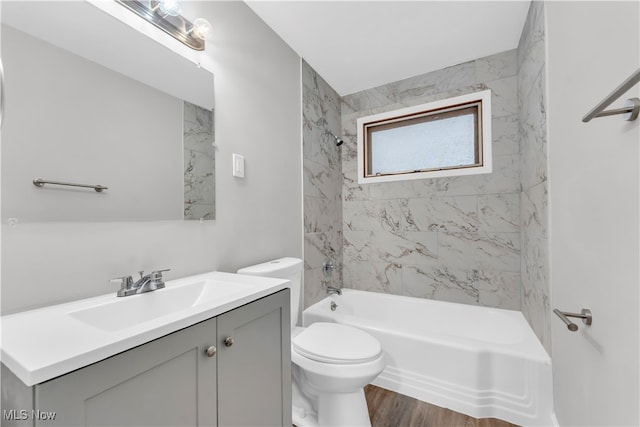 full bathroom with hardwood / wood-style floors, vanity, toilet, and tiled shower / bath