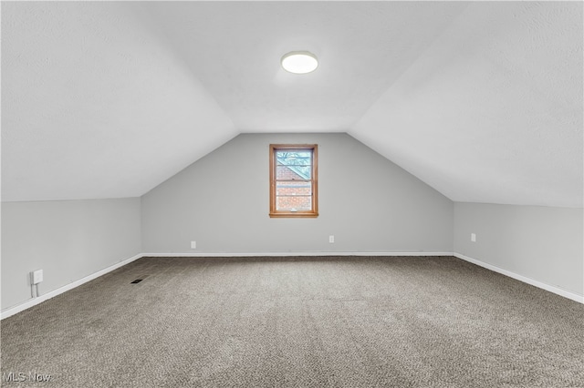 additional living space featuring carpet and lofted ceiling