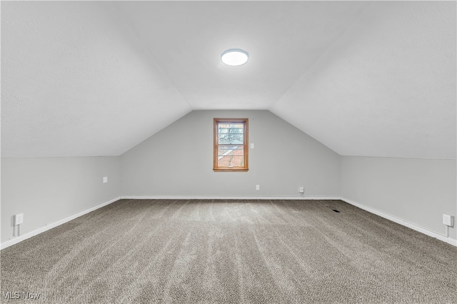 additional living space featuring carpet flooring and lofted ceiling