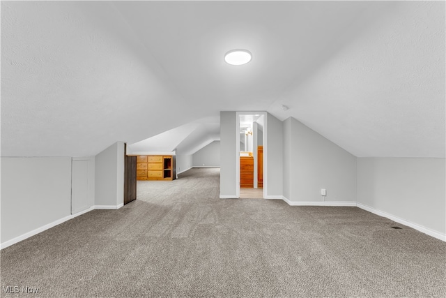 bonus room featuring carpet and vaulted ceiling