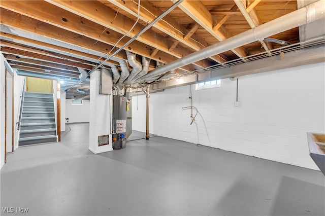 basement featuring a wealth of natural light and water heater