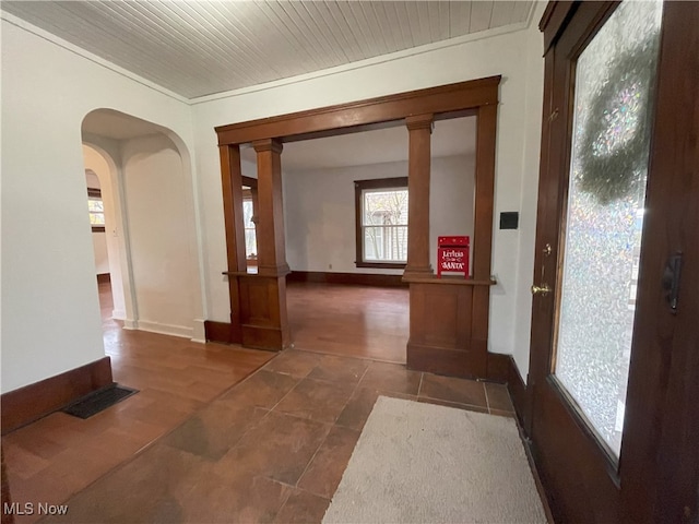 hall featuring ornamental molding and decorative columns