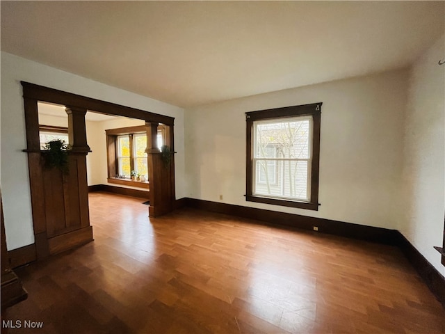 empty room with hardwood / wood-style floors and plenty of natural light