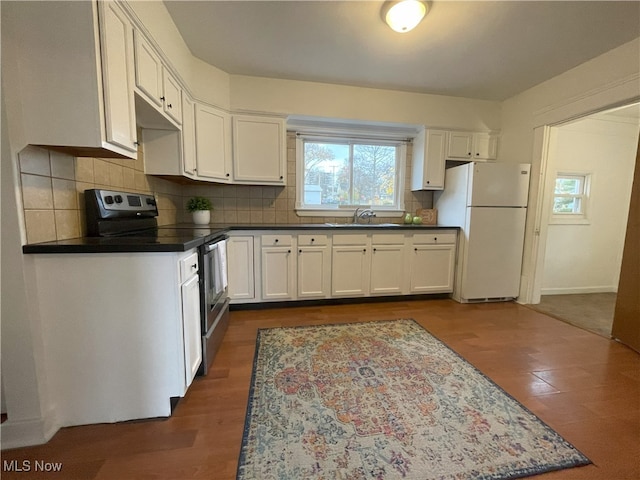 kitchen with white cabinetry, electric range, sink, backsplash, and white fridge