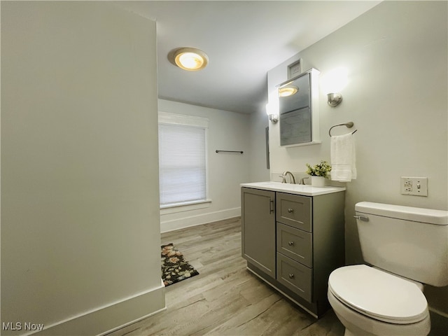 bathroom with hardwood / wood-style flooring, vanity, and toilet