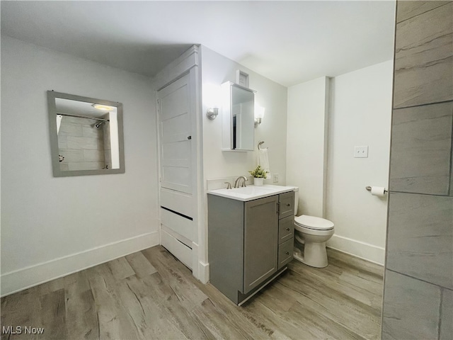 bathroom with vanity, wood-type flooring, and toilet