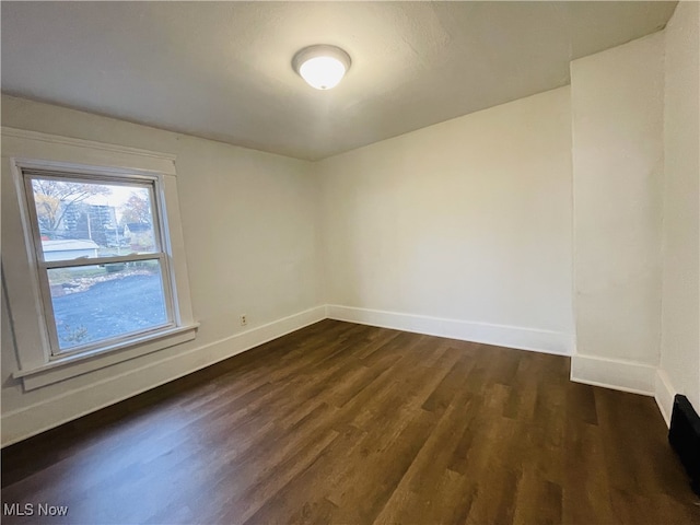 spare room with dark hardwood / wood-style flooring