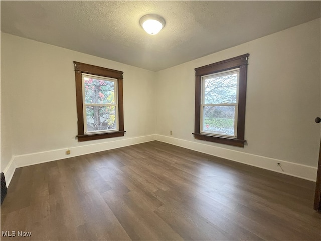 unfurnished room featuring dark hardwood / wood-style floors and a textured ceiling