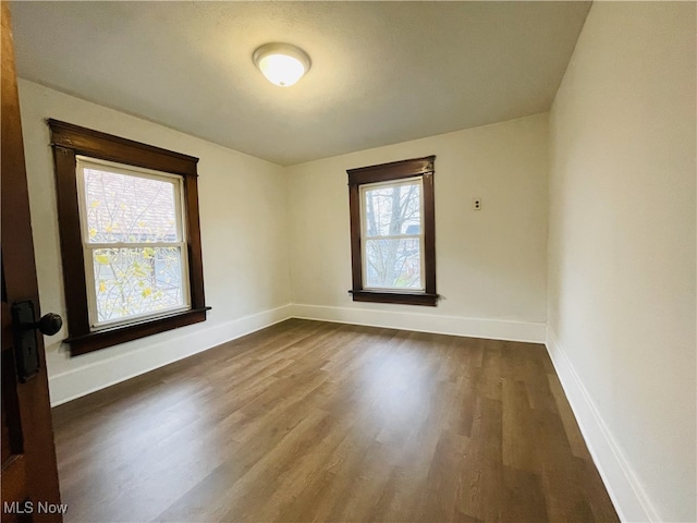 empty room with dark hardwood / wood-style flooring