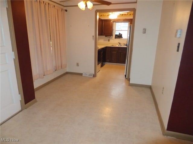 interior space featuring dark brown cabinetry, ceiling fan, sink, and refrigerator