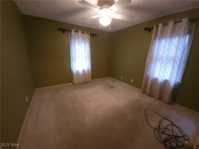 carpeted empty room with ceiling fan and a textured ceiling