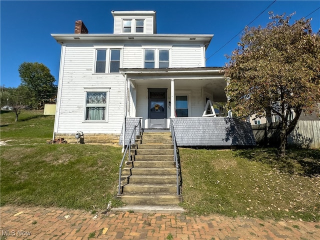 italianate-style house with a porch and a front yard