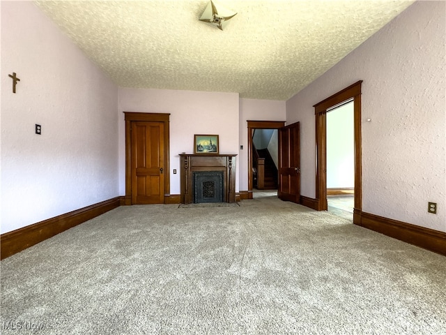 unfurnished living room featuring carpet floors and a textured ceiling