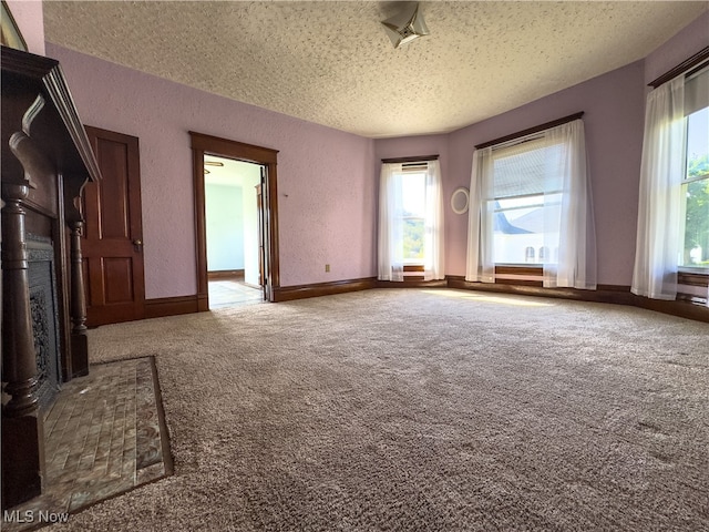 unfurnished living room with carpet floors and a textured ceiling