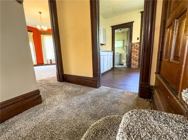 hallway featuring dark wood-type flooring and a chandelier