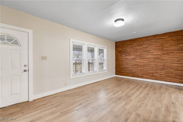 interior space with wood walls and light hardwood / wood-style floors