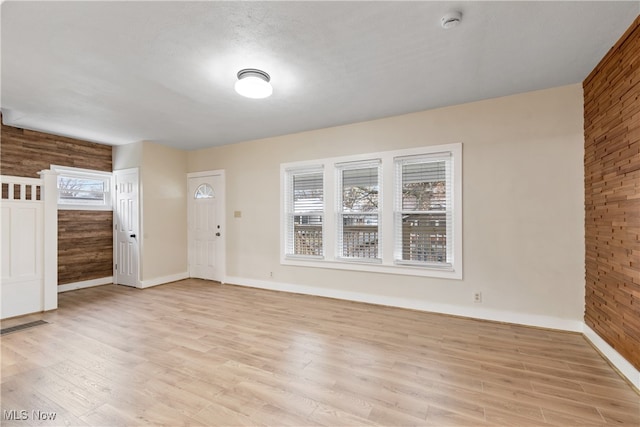 entryway with wood walls and light hardwood / wood-style floors