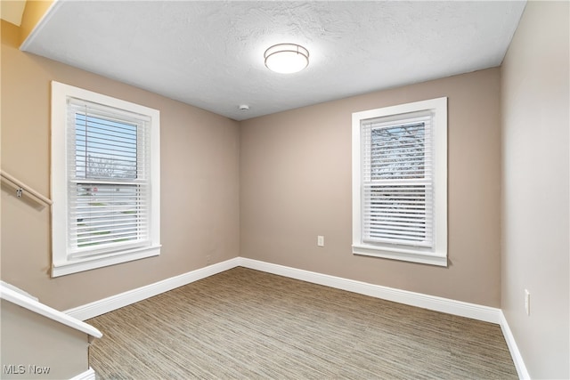 unfurnished room with a textured ceiling