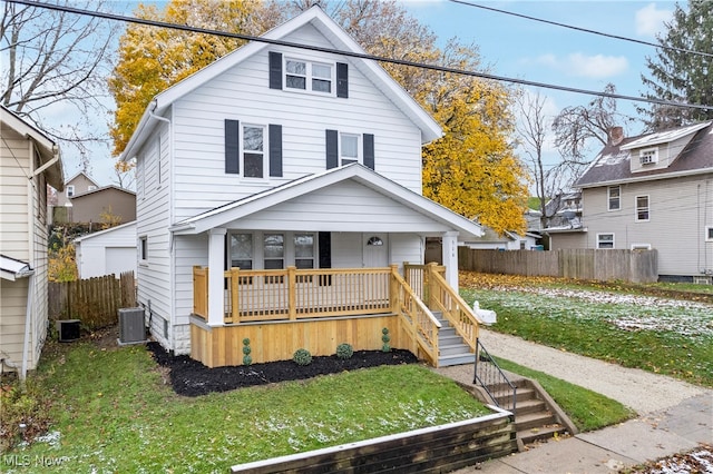 view of front facade featuring central air condition unit, a front lawn, and a porch