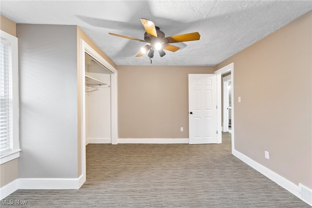 unfurnished bedroom featuring ceiling fan, a closet, light colored carpet, and a textured ceiling