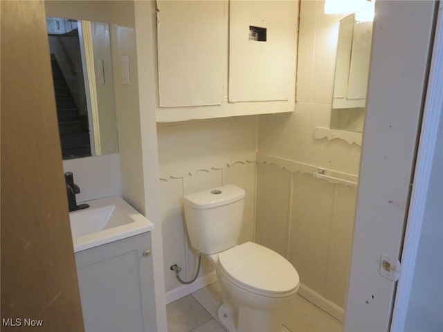 bathroom featuring tile patterned flooring, vanity, and toilet