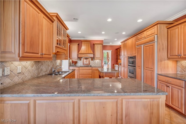 kitchen featuring custom exhaust hood, sink, ornamental molding, appliances with stainless steel finishes, and kitchen peninsula