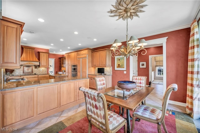 tiled dining area with crown molding, sink, and a chandelier