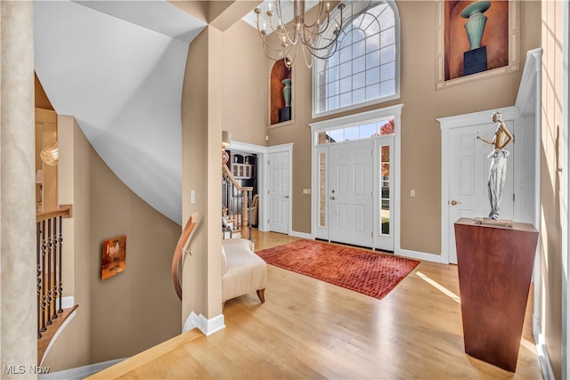 entrance foyer with a notable chandelier, a high ceiling, and light hardwood / wood-style flooring