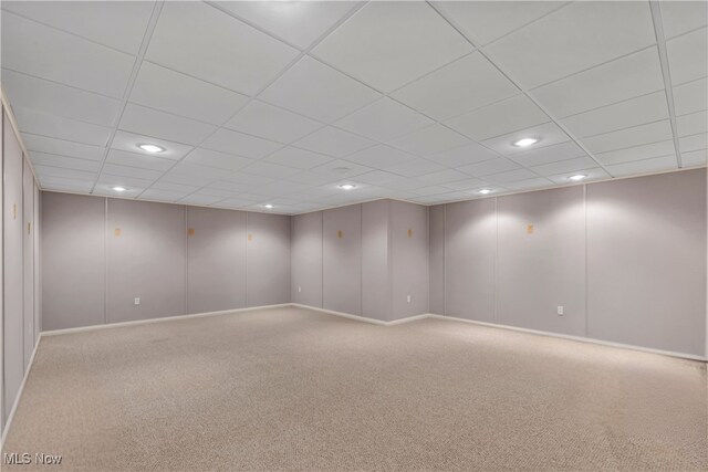 carpeted empty room with a drop ceiling