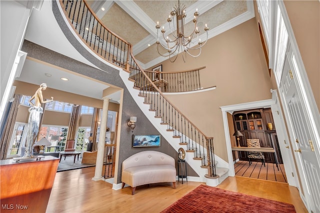 interior space with decorative columns, a high ceiling, and hardwood / wood-style flooring