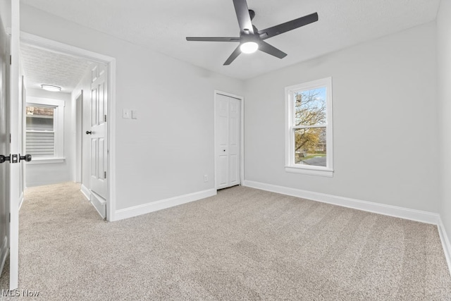 unfurnished bedroom featuring ceiling fan, a closet, and light colored carpet