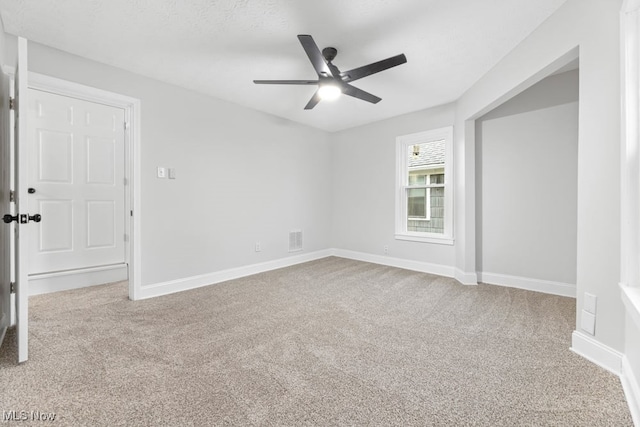 carpeted spare room with ceiling fan