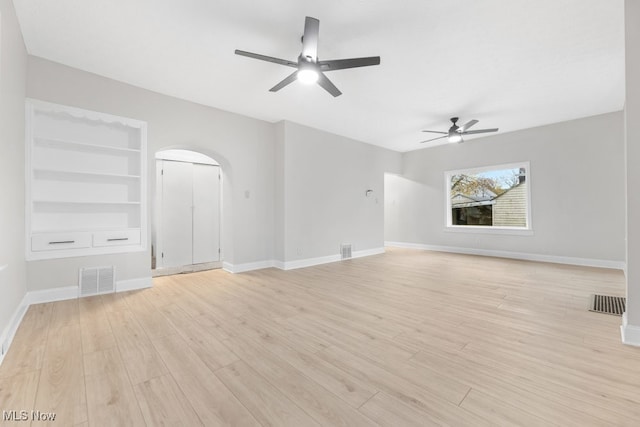 unfurnished living room featuring ceiling fan, built in features, and light hardwood / wood-style floors