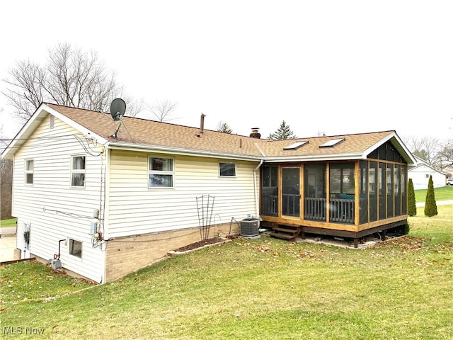 back of house with a lawn, central air condition unit, and a sunroom