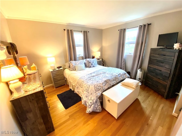 bedroom featuring light hardwood / wood-style flooring and crown molding