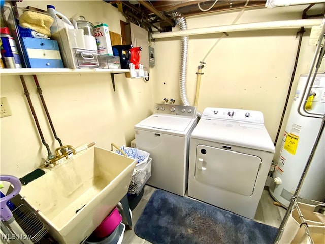 washroom featuring gas water heater, sink, and washing machine and clothes dryer