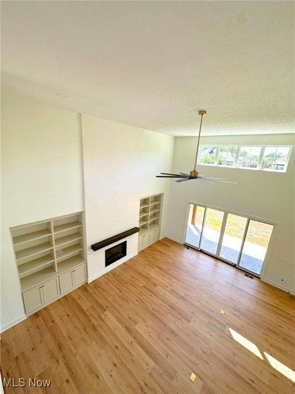 unfurnished living room featuring wood-type flooring and ceiling fan