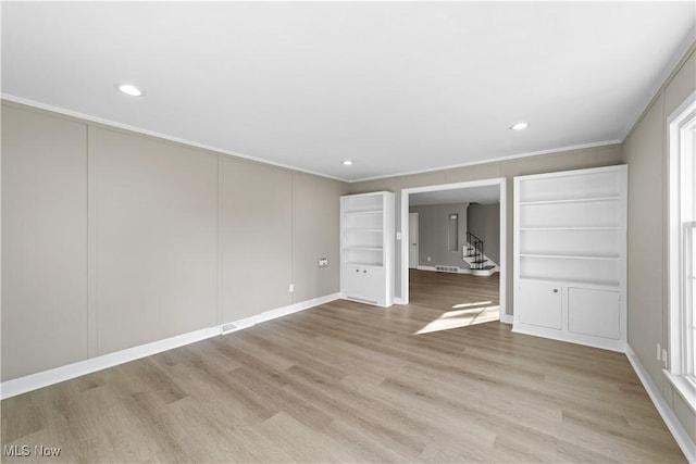 unfurnished bedroom with ornamental molding and light wood-type flooring