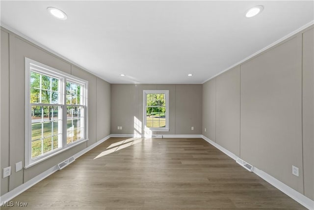 empty room featuring dark hardwood / wood-style flooring and ornamental molding