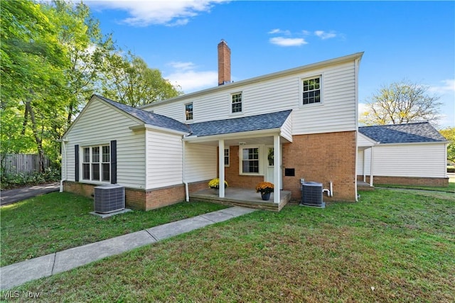 back of property with central AC and a yard