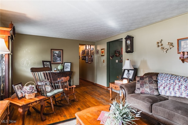 living room with wood-type flooring and a textured ceiling